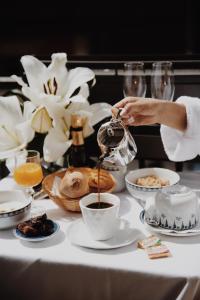 uma pessoa está derramando café em uma xícara em uma mesa em Waldorf Montparnasse em Paris