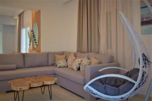 a living room with a couch and a hanging chair at Notos Villas in Frangokastello