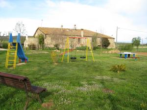 patio con parque infantil con columpio y banco en Mas Duran en La Pera