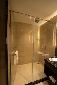 a glass shower in a bathroom with a sink at Hotel DVIJ INN in Jaipur