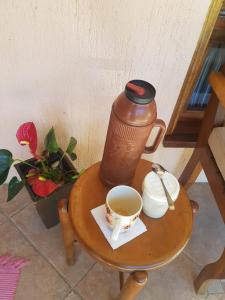 uma cafeteira e uma chávena de café numa mesa em QUARTO Jardim da Serra em Nova Petrópolis