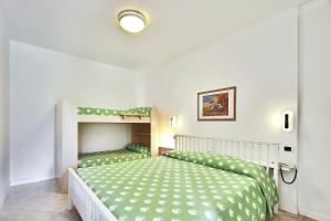 a bedroom with a bed and a bunk bed at Aparthotel Ponza in Lignano Sabbiadoro +38 photos