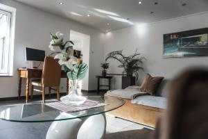 sala de estar con mesa de cristal y sofá en Neu gebautes Apartment mit Sonnenterasse in der Nähe vom Siebengebirge & Bonn en Königswinter