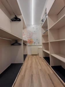 a walk in closet with white shelves and wooden floors at Apartamento Nuria in Figueres