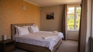 - une chambre avec un lit doté de draps blancs et une fenêtre dans l'établissement Solinaria Boutique Hotel, à Sozopol