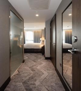 a hotel room with a bed and a door at voco Edinburgh - Haymarket, an IHG Hotel in Edinburgh