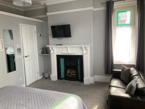 uma sala de estar com uma cama e uma lareira em Rivington House Room only em Whitby