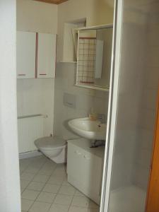 a white bathroom with a sink and a toilet at Hotel Pension Becker in Rothenburg ob der Tauber