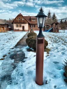 a street light in the snow in front of a house at Chalupa ŠŠ in Vlachy