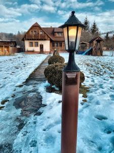 una luz de la calle en la nieve frente a una casa en Chalupa ŠŠ en Vlachy