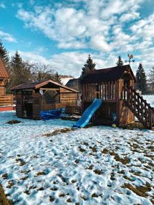 a playground with a slide in the snow at Chalupa ŠŠ in Vlachy