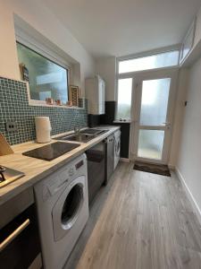 a kitchen with a washing machine and a sink at Little Haven in Dartmouth