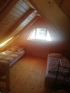 um quarto no sótão com 2 camas e uma janela em dom Bartków kielce em Zagnańsk
