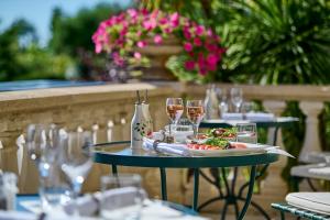 a table with glasses of wine and a plate of food at Hôtel La Grande Bastide in Saint-Paul-de-Vence