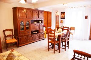 a dining room with a table and a large wooden cabinet at La Petite Maison in Cesseras