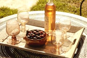 a bottle of wine and glasses on a table at La Petite Maison in Cesseras +9 photos