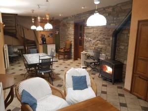 a living room with a fireplace and chairs and a stove at La Source d'Arimont in Malmedy