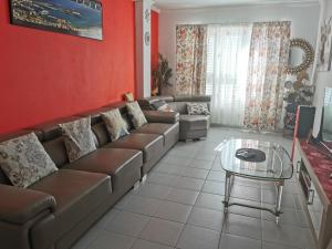 a living room with a couch and a table at Habitación con baño privado in Gáldar