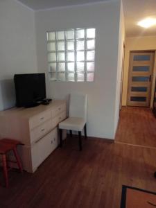 a living room with a tv and a desk with a chair at But in Pasłęk