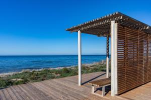 une terrasse en bois avec un kiosque et l'océan dans l'établissement Luca's Rooms, à Valledoria