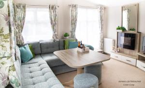 a living room with a couch and a table at Domki Center- Camp in Jarosławiec