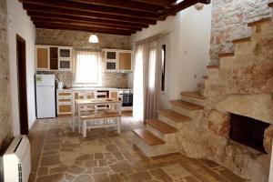 a kitchen with a staircase and a stone wall at Fruit Garden Villas in Kriopigi