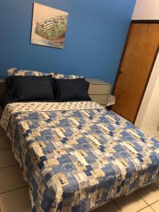 1 dormitorio con 1 cama con pared azul en Combate Green House en Cabo Rojo