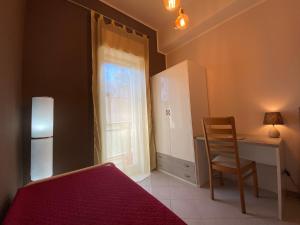 a bedroom with a bed and a desk and a window at Casa Vacanza nel cuore di Castellammare del golfo in Castellammare del Golfo