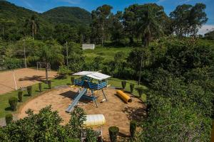 a playground with a slide in a park at Vila Olaria Hotel in Penha
