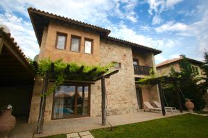 a stone house with a patio and a yard at Fruit Garden Villas in Kriopigi