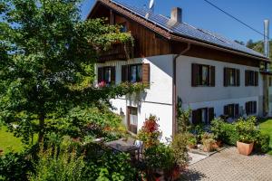 a white house with a bench in front of it at Ferienwohnung Irene Dorn // Andechs in Andechs