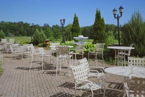 a group of chairs and tables and tables and trees at Comfort Suites in Edinboro