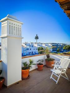 a balcony with two white chairs and a lighthouse at Cabanas Terraces - Pool and seaview in Tavira