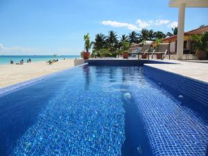 una piscina azul junto a una playa en Casa Moskito, en Playa del Carmen