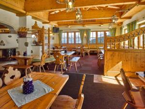 Habitación grande con mesas y sillas de madera. en Alpengasthof Hochsöll, en Söll