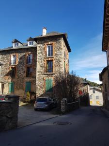 a stone building with a car parked in front of it at Grand appartement 130m2 à 5mn des stations de ski in Formiguères