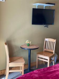 a table and two chairs and a tv on a wall at Noble Motel in Norland