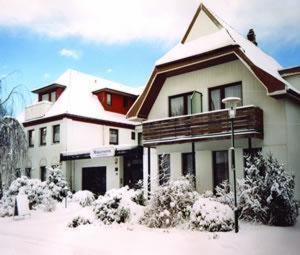 una casa con nieve en la parte delantera en Hotel Morgensonne garni, en Büsum