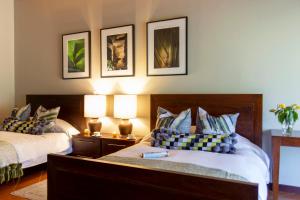 a bedroom with two beds and two lamps on the wall at Hotel Boutique y Restaurante Panisté in Santa Cruz Verapaz