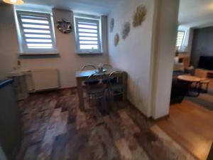 salon ze stołem, krzesłami i oknami w obiekcie Apartamet 45 w mieście Płock