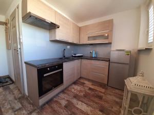 a kitchen with wooden cabinets and a sink and a refrigerator at Apartamet 45 in Płock