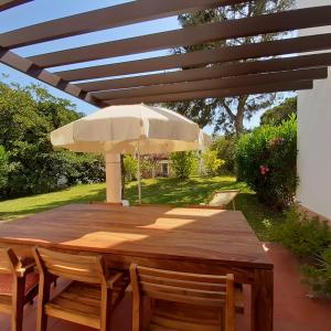 a wooden table with an umbrella on a patio at Quinta do Lago Villa and Golf in Quinta do Lago