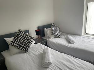 a bedroom with two beds with pillows and a window at Gateway Mews WV1 - Budget Contractor Stays- 5 Beds in Monmore Green