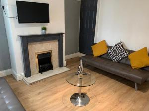 a living room with a couch and a fireplace at Gateway Mews WV1 - Budget Contractor Stays- 5 Beds in Monmore Green