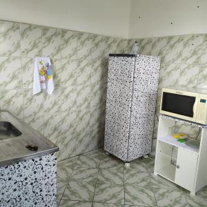 uma pequena cozinha com um micro-ondas e um frigorífico em Quarto Duplo Confort em Barueri