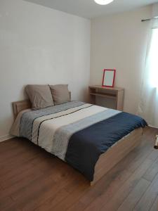 um quarto com uma cama grande e piso em madeira em Boissy Gare RER A Appartement 1 à 3 chambres au choix em Boissy-Saint-Léger