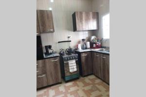 una cucina con armadi in legno e piano cottura. di Well furnished and spacious 2 bedroom apartment ad Abuja
