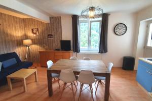 salon z drewnianym stołem i krzesłami w obiekcie Appartement La Bresse w mieście La Bresse