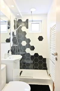 baño con una pared de azulejos en blanco y negro en Sophia's Cozy Apartment, en Mediaş
