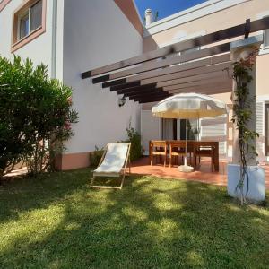 un patio con sombrilla, silla y mesa en Quinta do Lago Villa and Golf, en Quinta do Lago